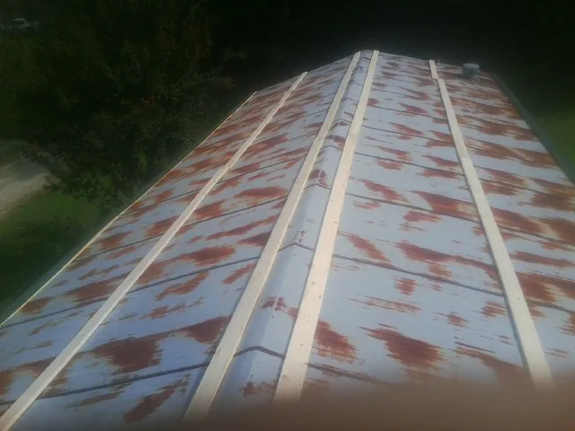 Rusted metal roof panels with new wood purlins before replacement — Storm Damage Roof Repair in Little Falls by Roofing Brothers