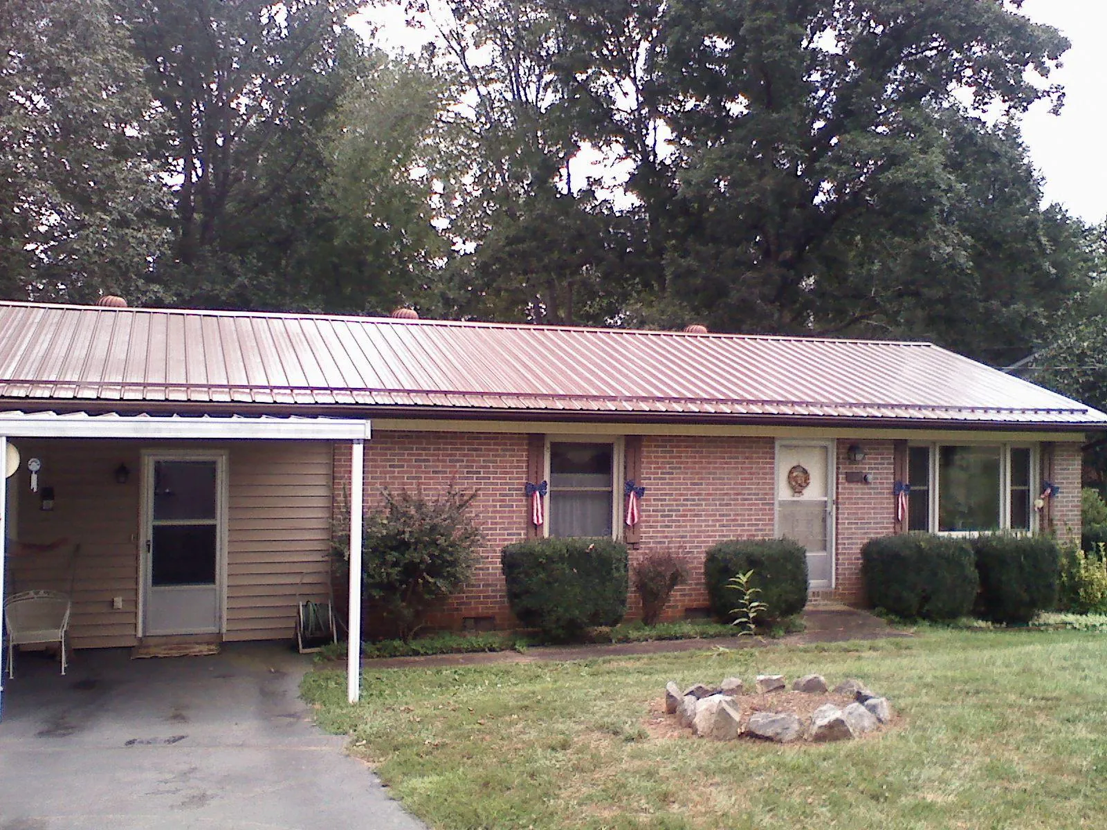Bronze metal roof and carport on a brick ranch home — Roof Repair work by our crew in Little Falls
