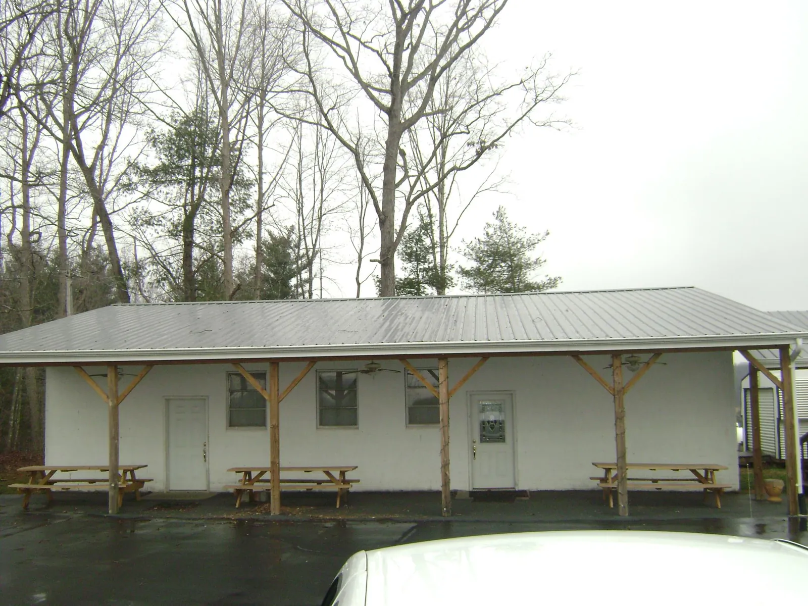Gray metal roof over a block building with a timber post porch in Little Falls